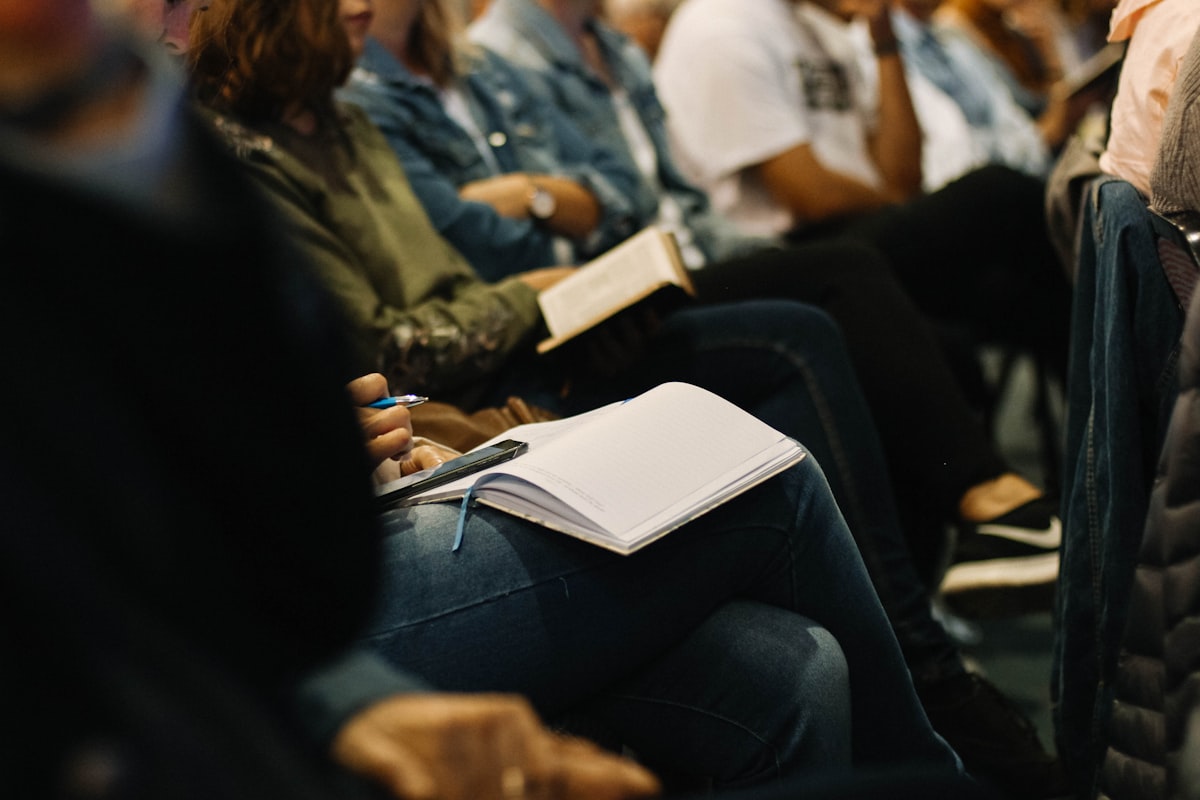 A congregation seated with open Bibles and notebooks during a teaching