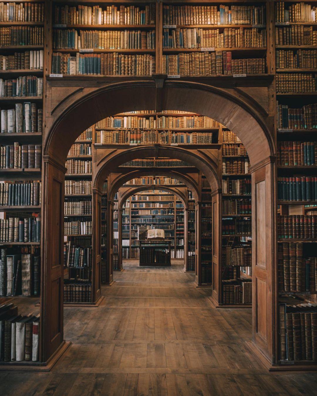Arched aisles of an old library lined with books