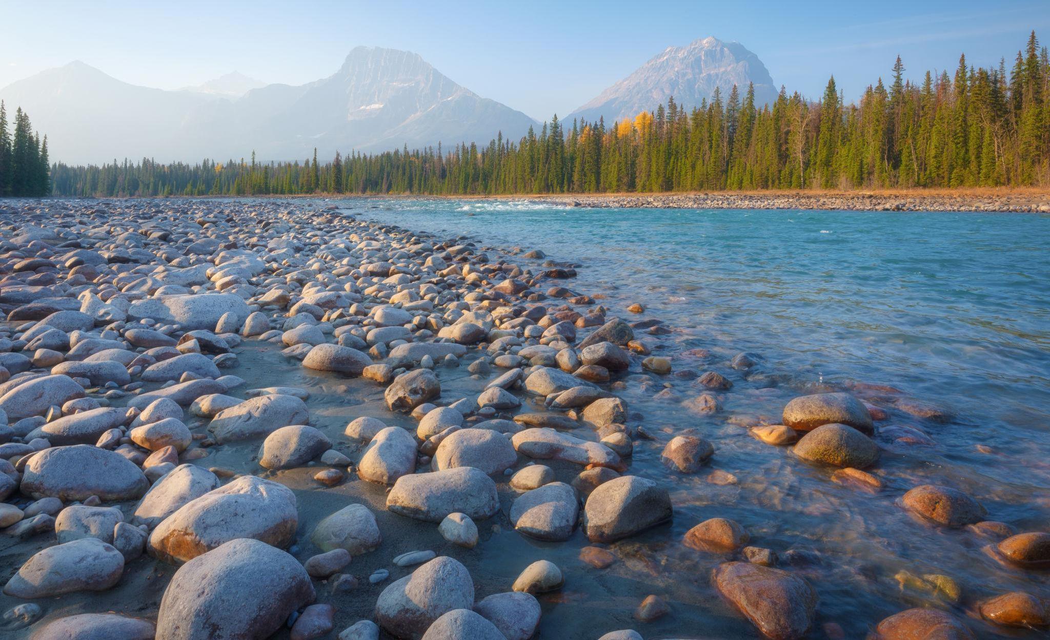 Mountain river with a pebbled shore at sunrise